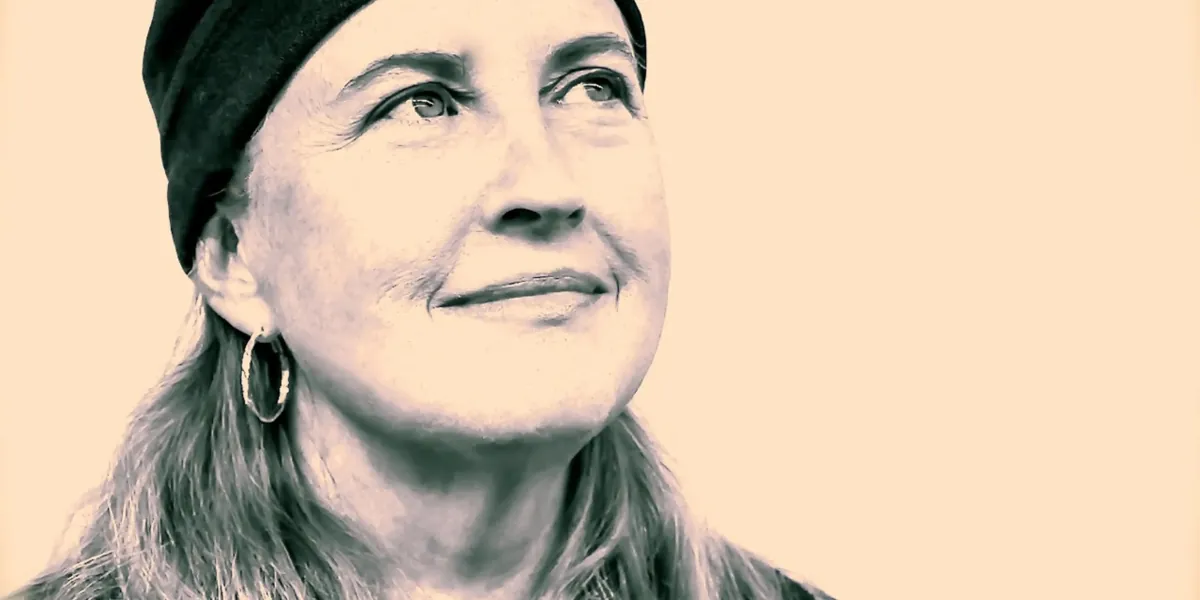 Close-up portrait of singer-songwriter Amy Coffman wearing a dark knit hat and hoop earrings.